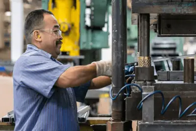 Evans operator running a stamping press fitted with progressive tooling